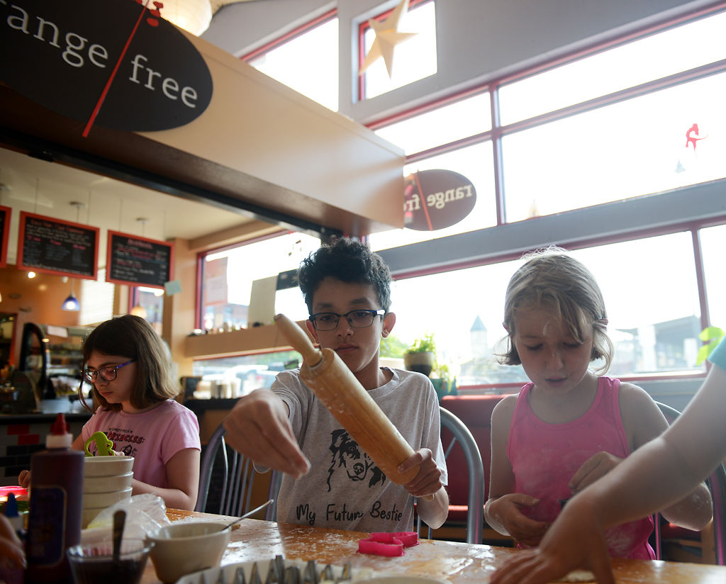 Charlotte Foster, 11, Tavian Rowles, 14, and Rose Landrum, 9, roll and stamp out sugar cookies